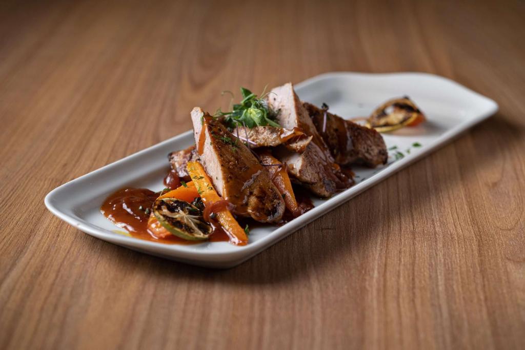 a plate of food with meat and vegetables on a table at Hampton by Hilton Riga Airport in Riga