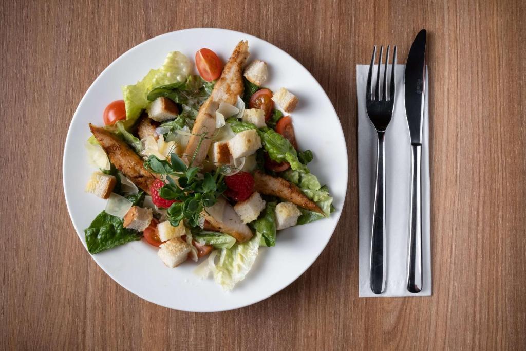 a plate of food with a salad on a table at Hampton by Hilton Riga Airport in Riga