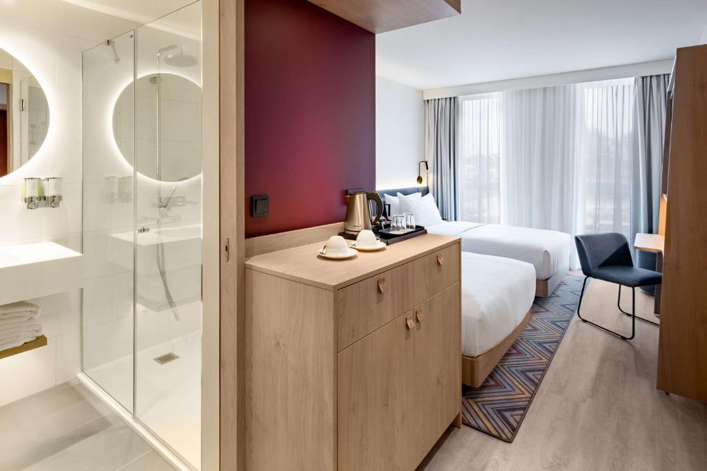 a hotel room with a bed and a bathroom at Hampton by Hilton Riga Airport in Riga