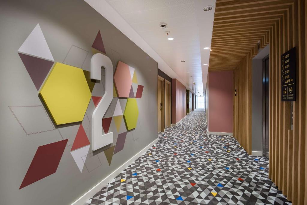 a hallway with a colorful painting on the wall at Hampton by Hilton Riga Airport in Riga