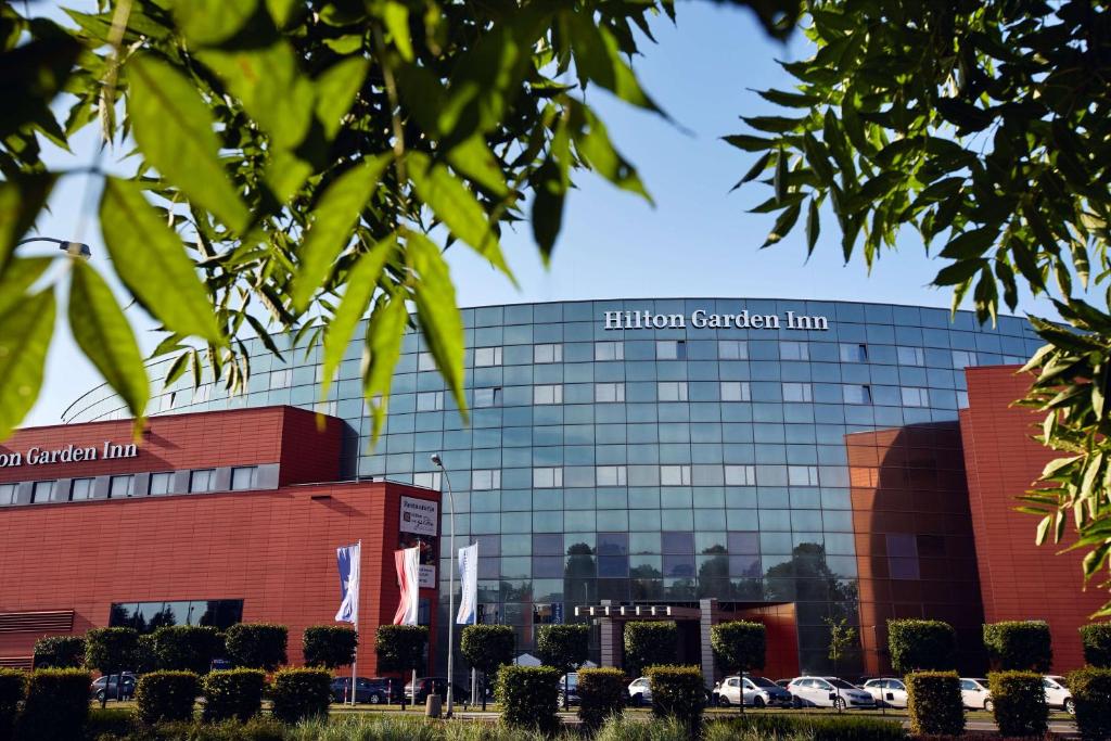 a building with cars parked in front of it at Hilton Garden Inn Rzeszów in Rzeszów