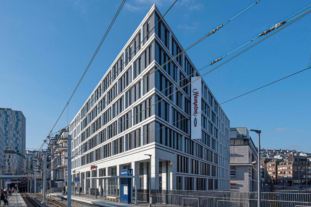 Hampton by Hilton Stuttgart City Centre في شتوتغارت: مبنى زجاجي طويل على شارع المدينة