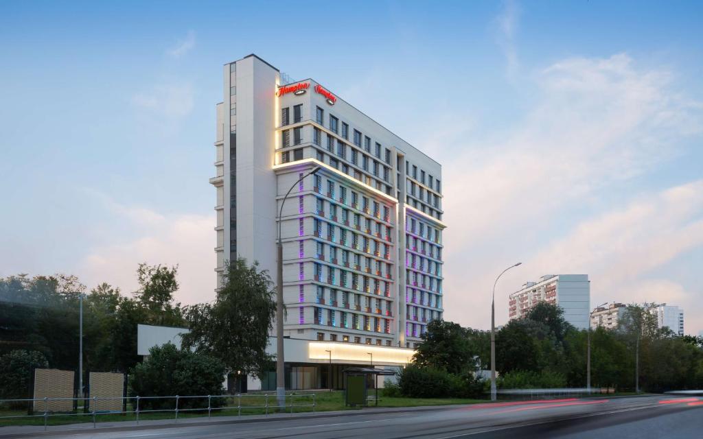 een hoog wit gebouw aan de kant van een straat bij Hampton By Hilton Moscow Rogozhsky Val in Moskou