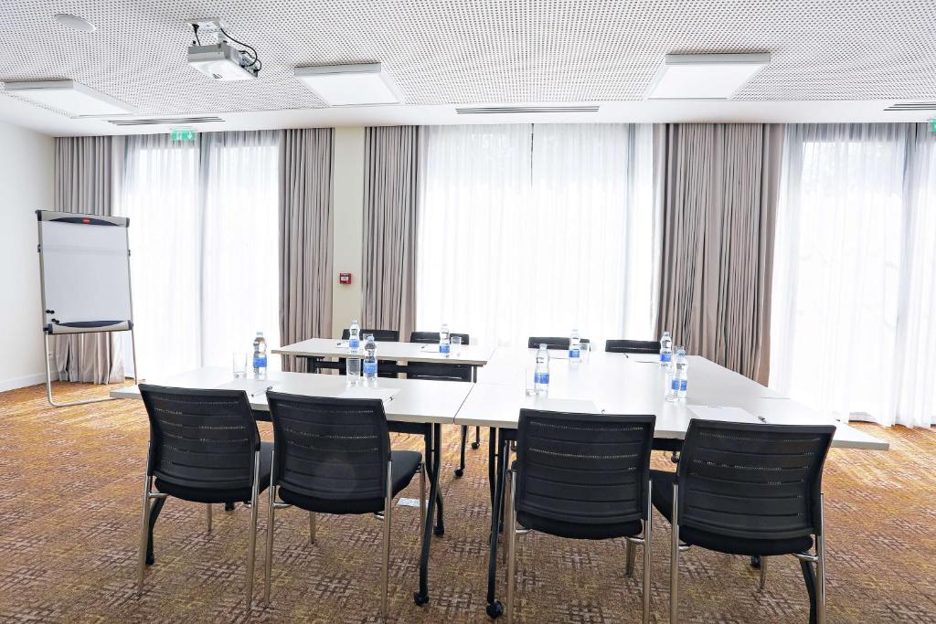 a conference room with a white table and chairs at Hampton By Hilton Toulouse Airport in Blagnac