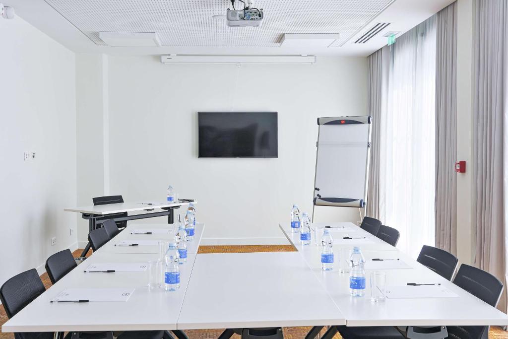 a conference room with a long table and chairs at Hampton By Hilton Toulouse Airport in Blagnac