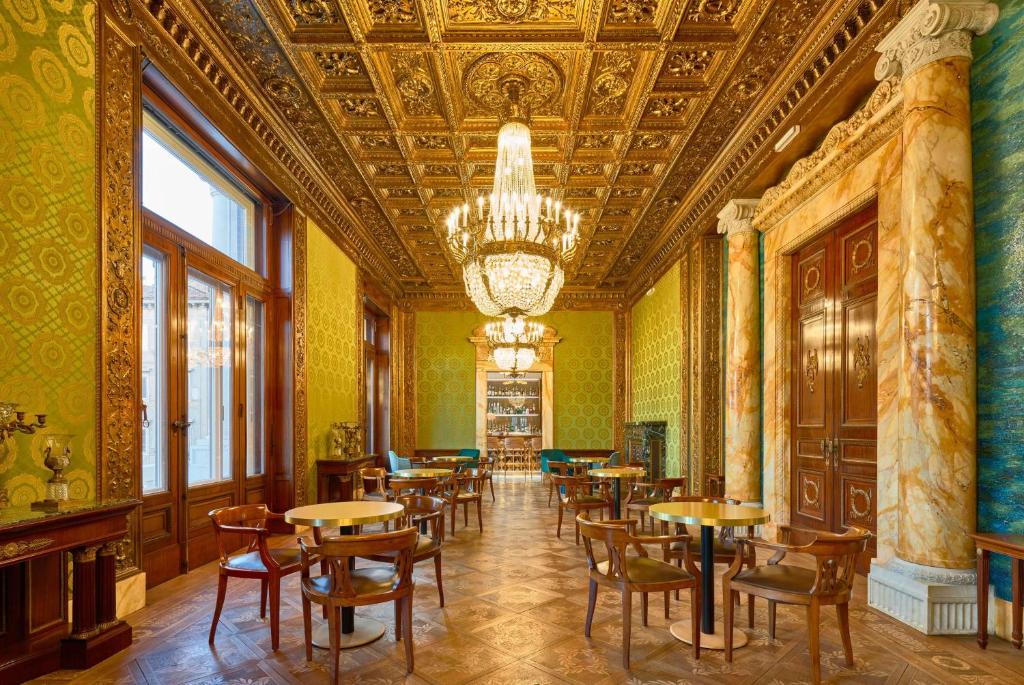 a dining room with tables and chairs and a chandelier at DoubleTree By Hilton Trieste in Trieste