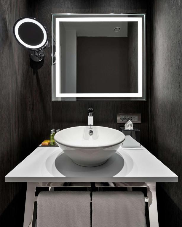 a bathroom with a white sink and a mirror at DoubleTree By Hilton Trieste in Trieste