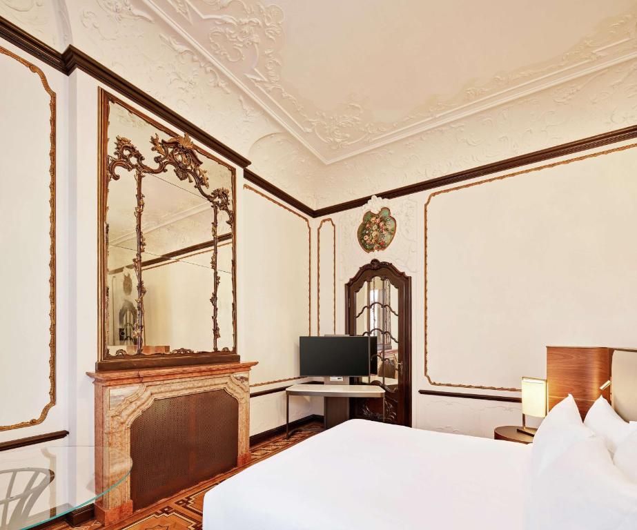 a bedroom with a bed and a mirror and a television at DoubleTree By Hilton Trieste in Trieste