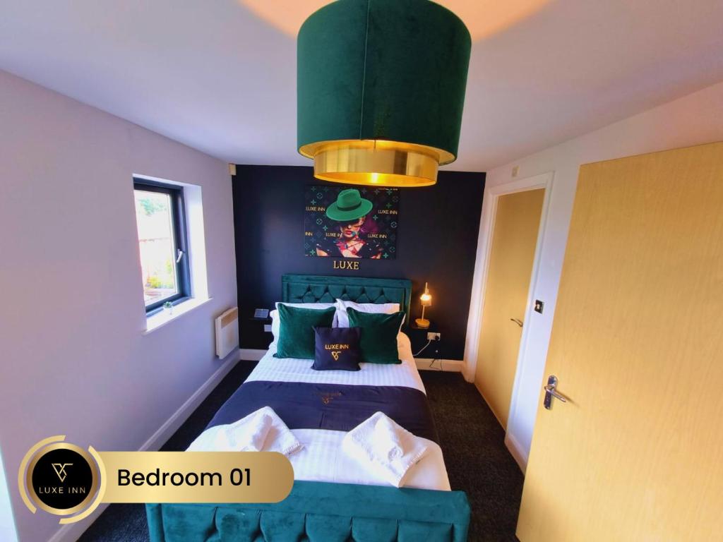 a bedroom with a bed with a green headboard at Bull's Ring 3Bed Penthouse City Centre in Birmingham
