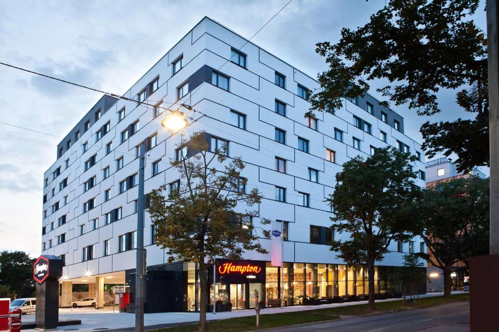 un edificio blanco con una luz de la calle delante de él en Hampton By Hilton Vienna Messe en Viena