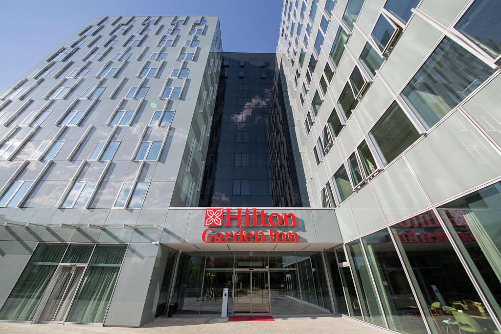 a tall building with a sign in front of it at Hilton Garden Inn Zagreb - Radnička in Zagreb