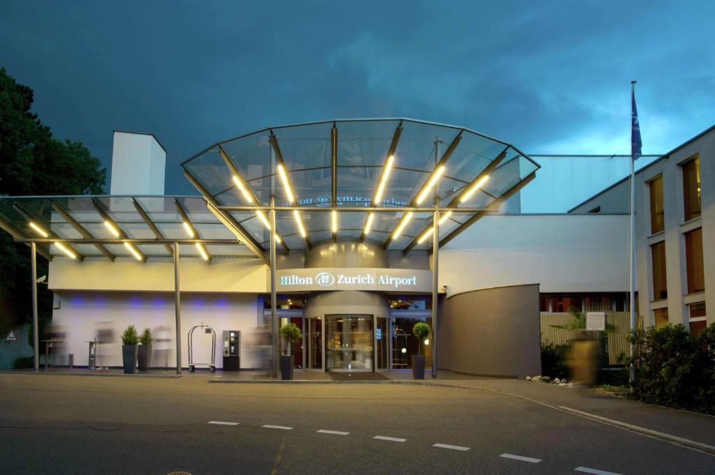 uma vista nocturna de um hospital com um edifício em Hilton Zurich Airport em Opfikon