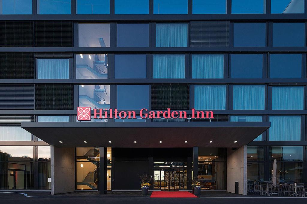 a building with a sign that reads helium garden inn at Hilton Garden Inn Zurich Limmattal in Spreitenbach