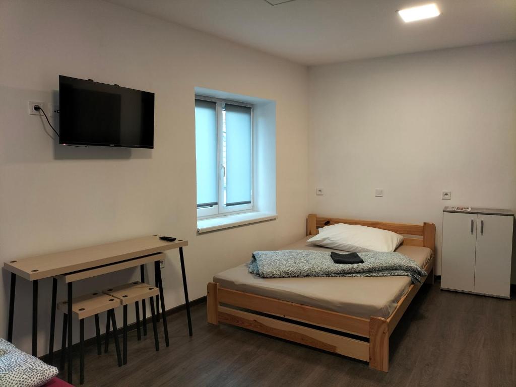 sypialnia z łóżkiem i biurkiem z telewizorem na ścianie w obiekcie Horizont w mieście Bulhary