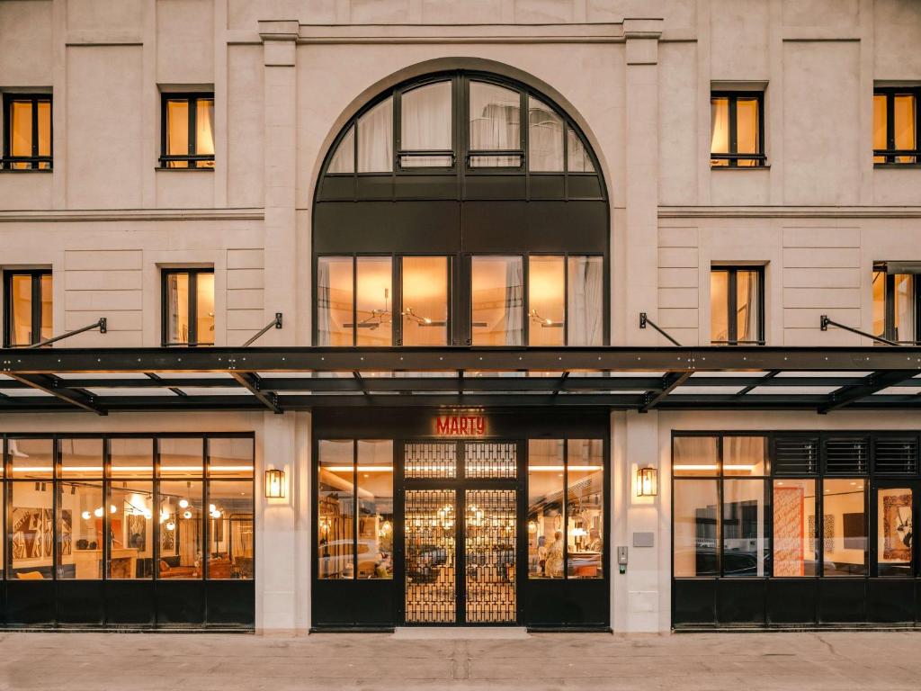 una tienda frente a un edificio con ventanas en Marty Hotel Bordeaux - Tapestry Collection by Hilton, en Burdeos