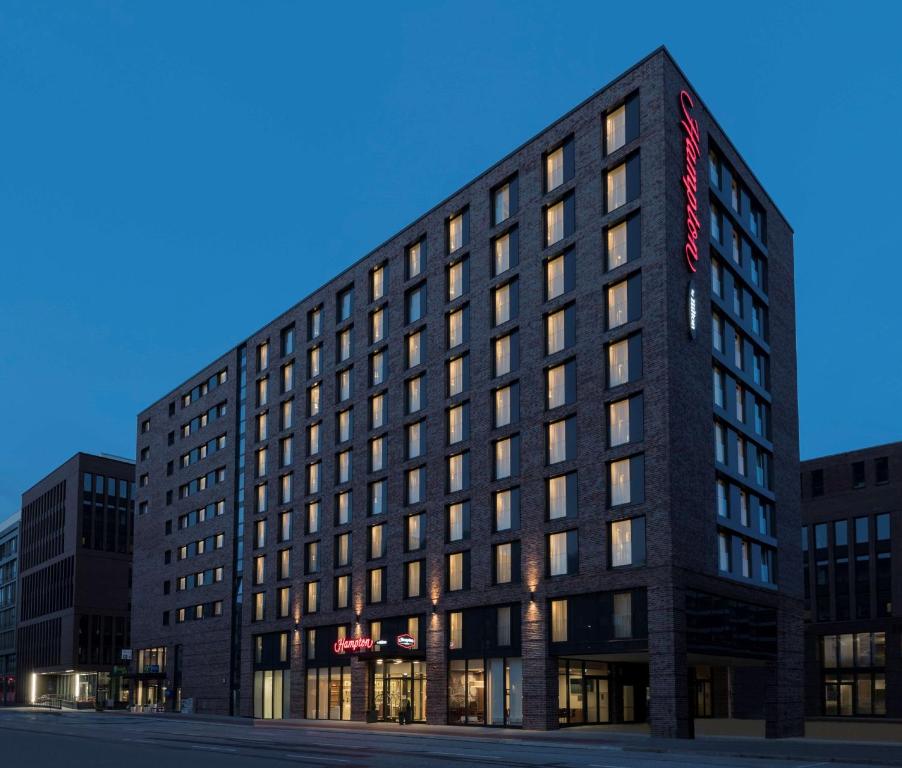 Un grand bâtiment noir avec un panneau rouge. dans l'établissement Hampton By Hilton Hamburg City Centre, à Hambourg