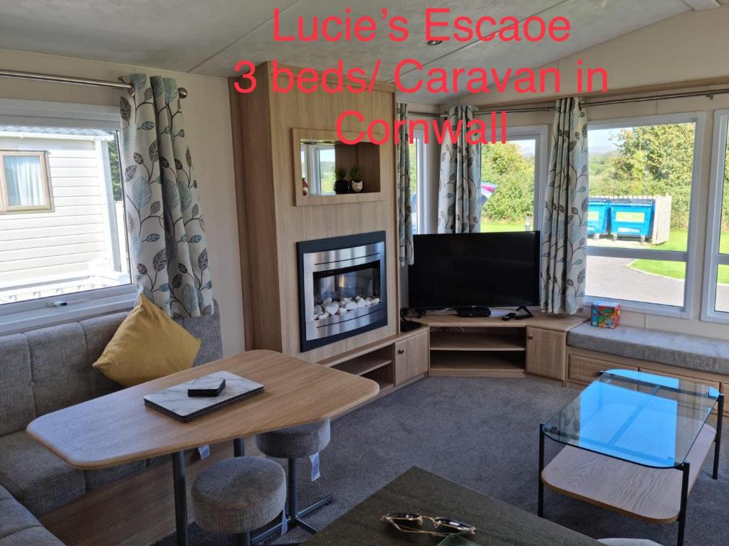 a living room with a couch and a tv at Lucie’s Escape/ 129 meadow view in Grampound