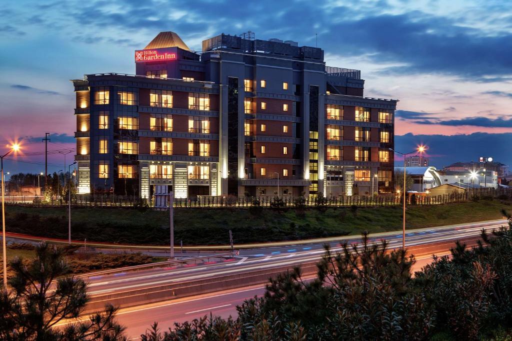 a building with a sign on top of it next to a highway at Hilton Garden Inn Corlu in Çorlu