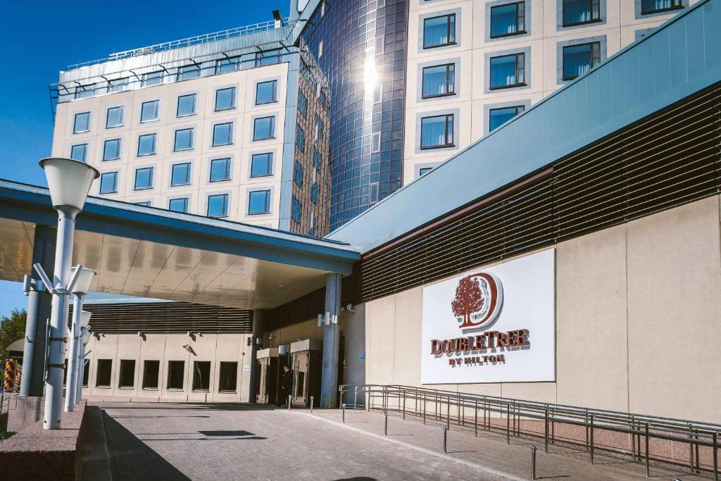 un edificio con un cartel en el costado en DoubleTree by Hilton Hotel Tyumen, en Tyumen