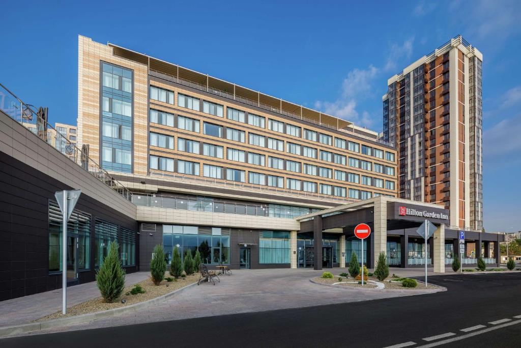 un grand bâtiment avec un panneau d'arrêt devant lui dans l'établissement Hilton Garden Inn Novorossiysk, à Novorossiisk
