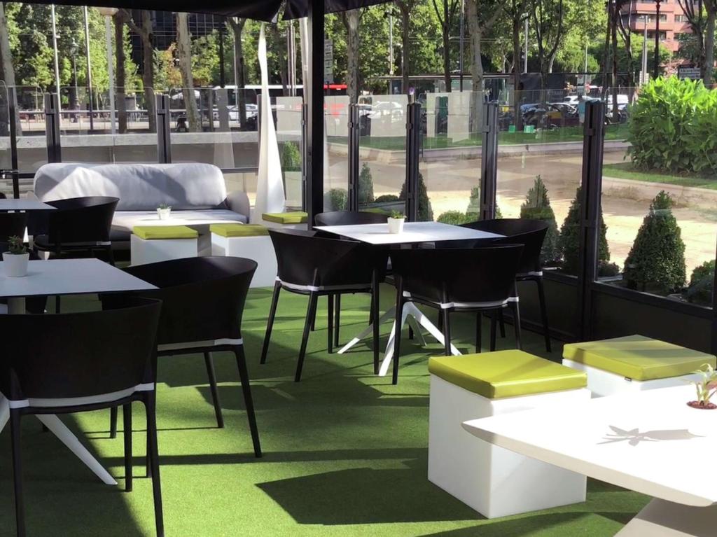 a restaurant with tables and chairs on a patio at Hilton Barcelona in Barcelona