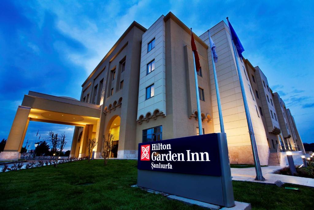 znak hotelowy w ogrodzie przed budynkiem w obiekcie Hilton Garden Inn Sanliurfa w mieście Şanlıurfa