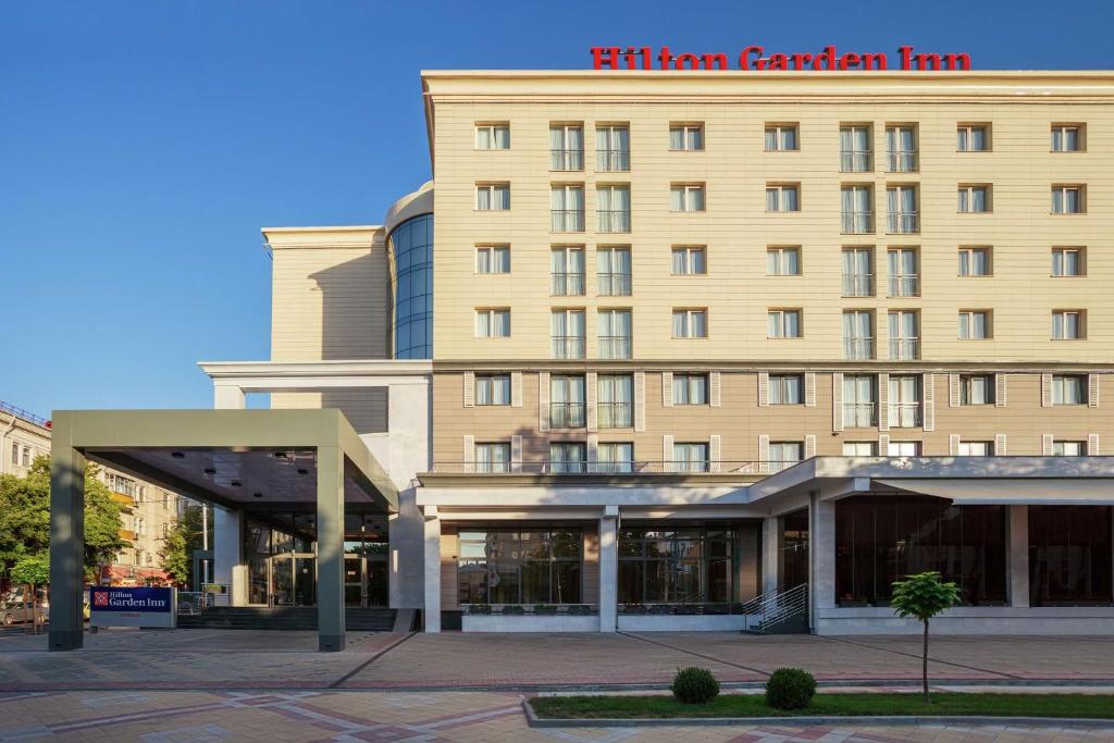 un grand bâtiment bien exposé avec un panneau sur lui dans l'établissement Hilton Garden Inn Krasnodar, à Krasnodar