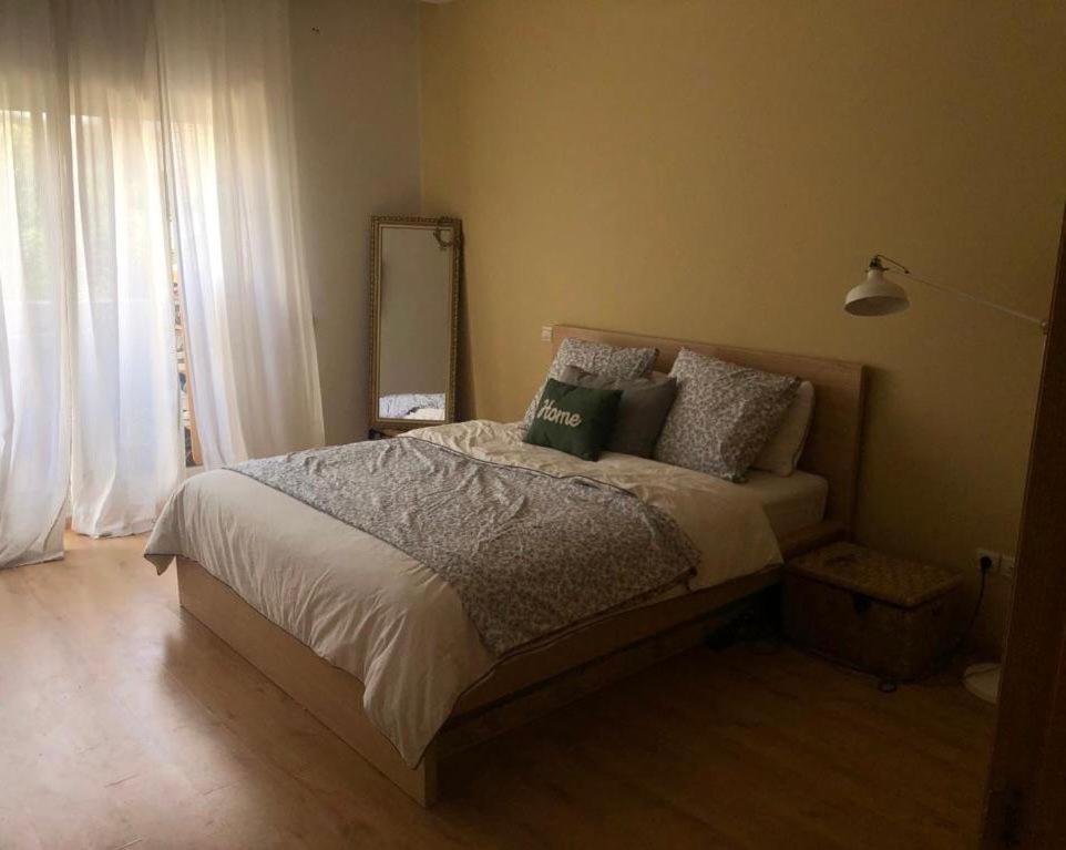 ein Schlafzimmer mit einem Bett mit Kissen und einem Spiegel in der Unterkunft Appartement meublé à louer in Settat