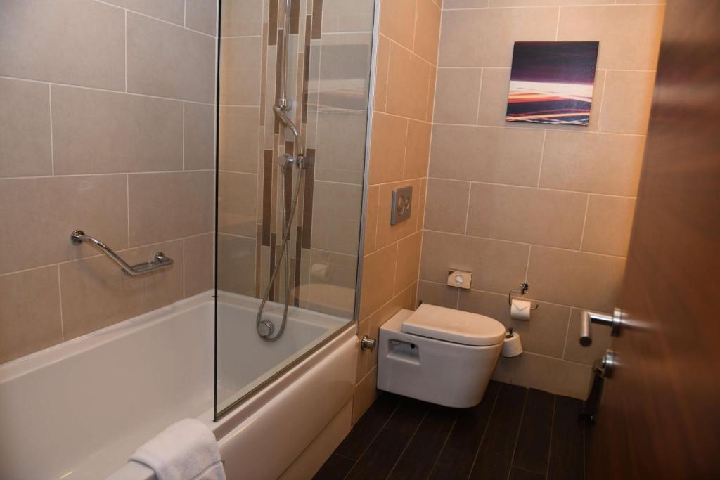 a bathroom with a shower and a toilet and a sink at Hilton Garden Inn Konya in Konya