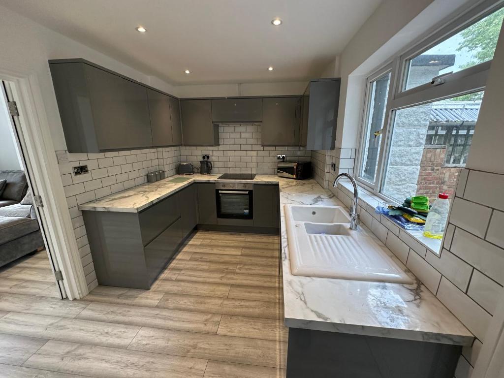 uma cozinha com um lavatório e uma bancada em 3 bedroom house Maidstone em Maidstone