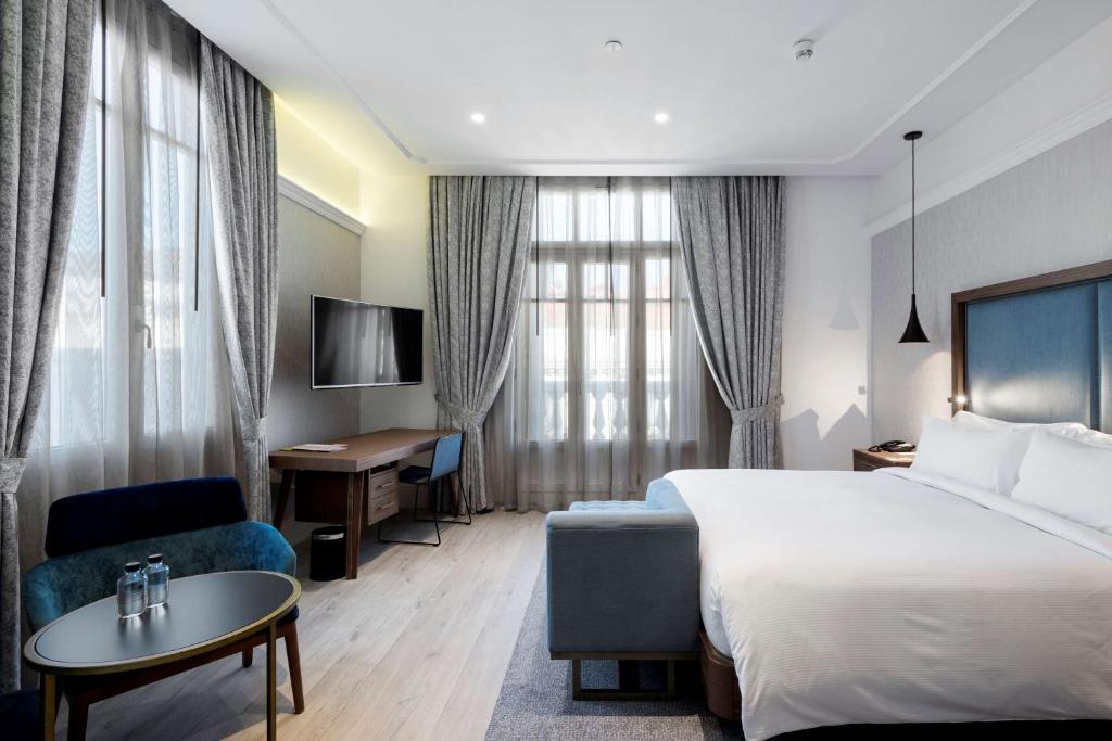 een hotelkamer met een bed en een bureau bij DoubleTree by Hilton Madrid-Prado in Madrid
