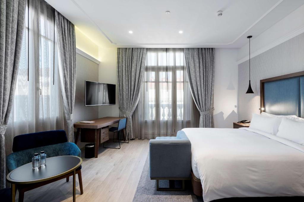pokój hotelowy z łóżkiem i biurkiem w obiekcie DoubleTree by Hilton Madrid-Prado w Madrycie