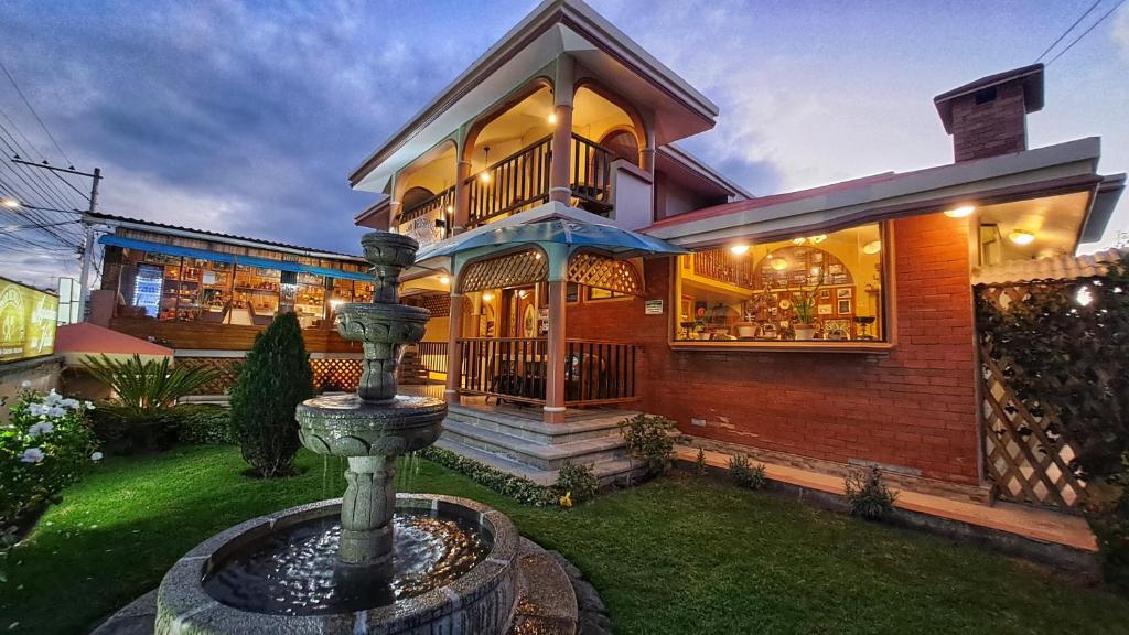 a house with a fountain in the yard at Mirador de Bellavista Riobamba in Riobamba