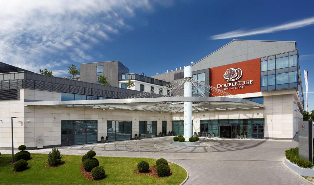 un edificio con un cartel en la parte delantera en DoubleTree by Hilton Hotel & Conference Centre Warsaw en Varsovia