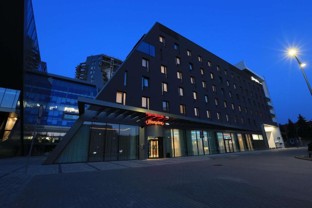 un bâtiment dans une ville la nuit dans l'établissement Hampton By Hilton Olsztyn, à Olsztyn