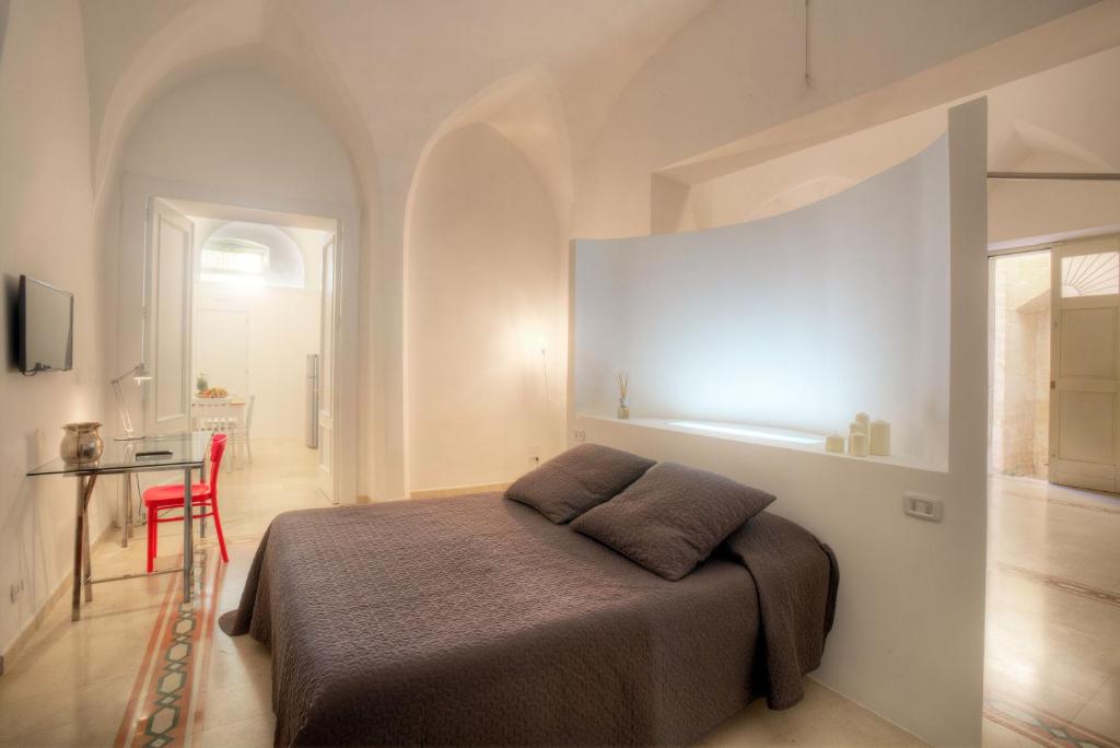 1 dormitorio con 1 cama y 1 silla roja en Nonna Jole, en Lecce