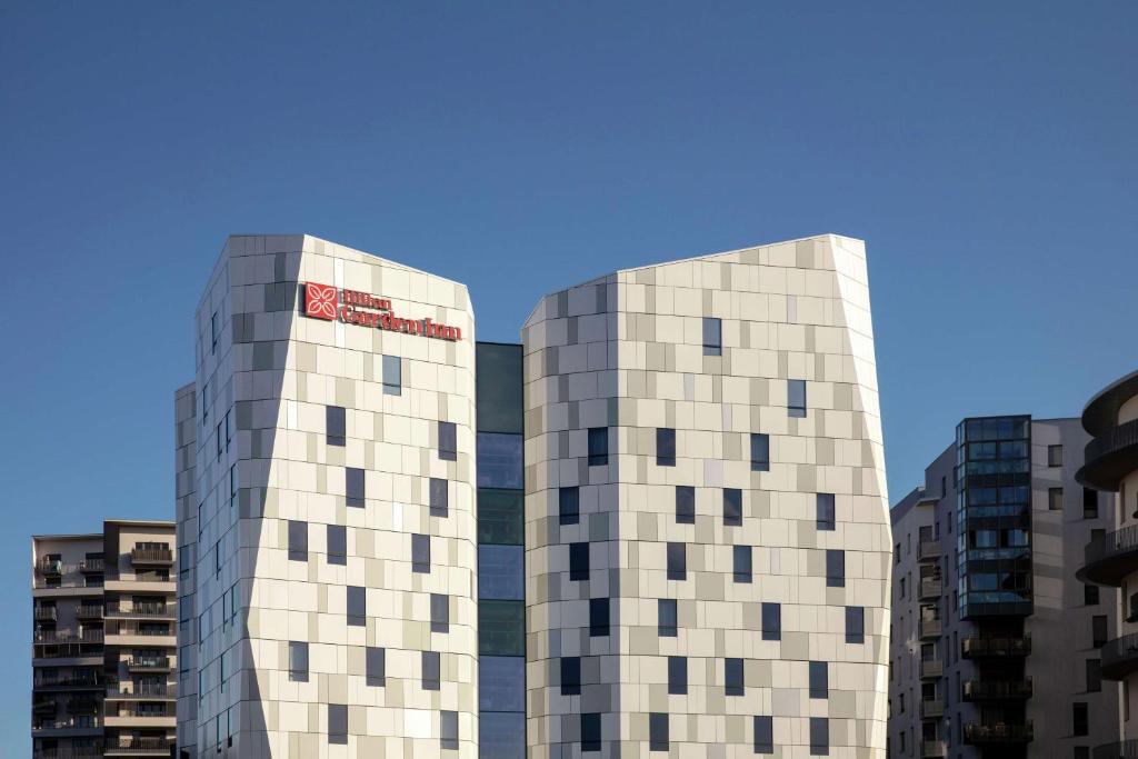 dos altos edificios blancos uno al lado del otro en Hilton Garden Inn Paris Massy, en Massy