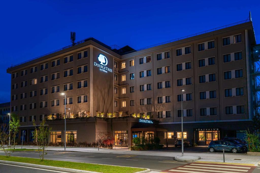 un edificio de hotel con un coche aparcado delante de él en DoubleTree by Hilton Brescia, en Brescia