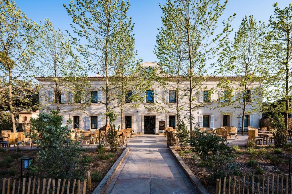 - une vue sur l'extérieur d'un bâtiment avec des arbres dans l'établissement Le Hameau Des Pesquiers Ecolodge & Spa, Curio Collection By Hilton, à Hyères