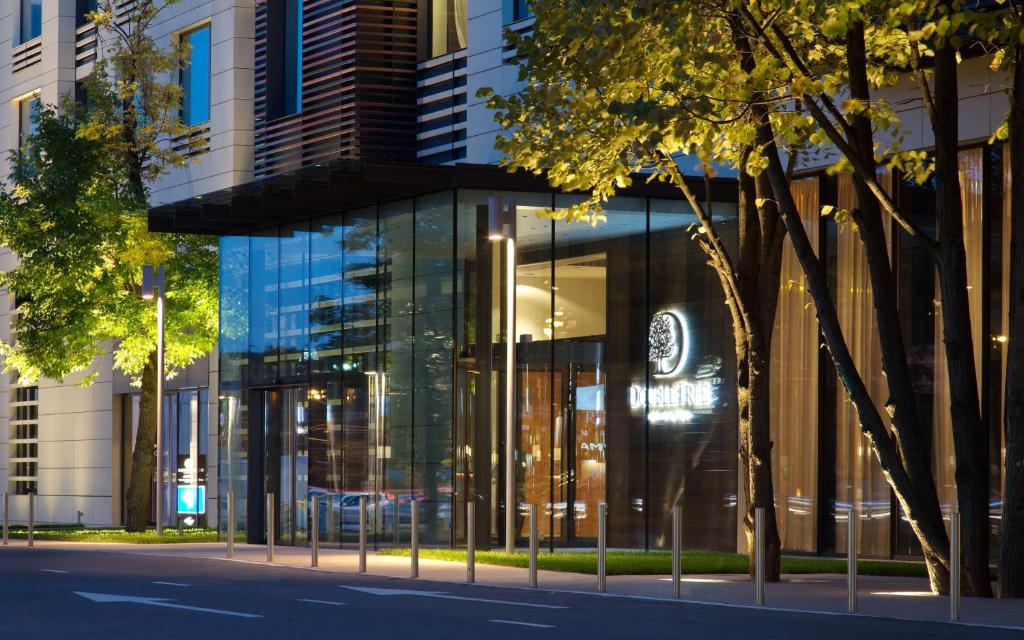 a building with a glass facade on a city street at DoubleTree by Hilton Moscow – Marina in Moscow