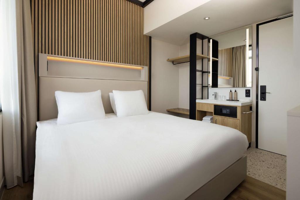 Postel nebo postele na pokoji v ubytování Motto By Hilton Rotterdam Blaak