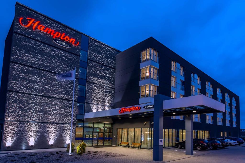 a building with a sign on the side of it at Hampton by Hilton Gdansk Airport in Gdańsk-Rębiechowo