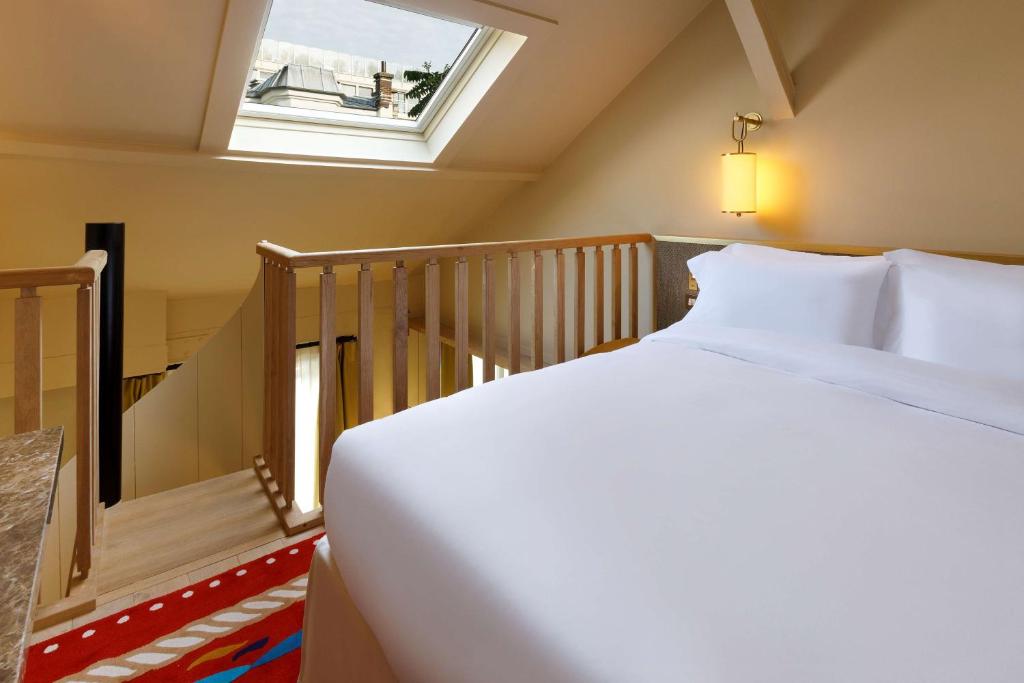 Cama ou camas em um quarto em Le Belgrand Hotel Paris Champs Elysees, Tapestry By Hilton