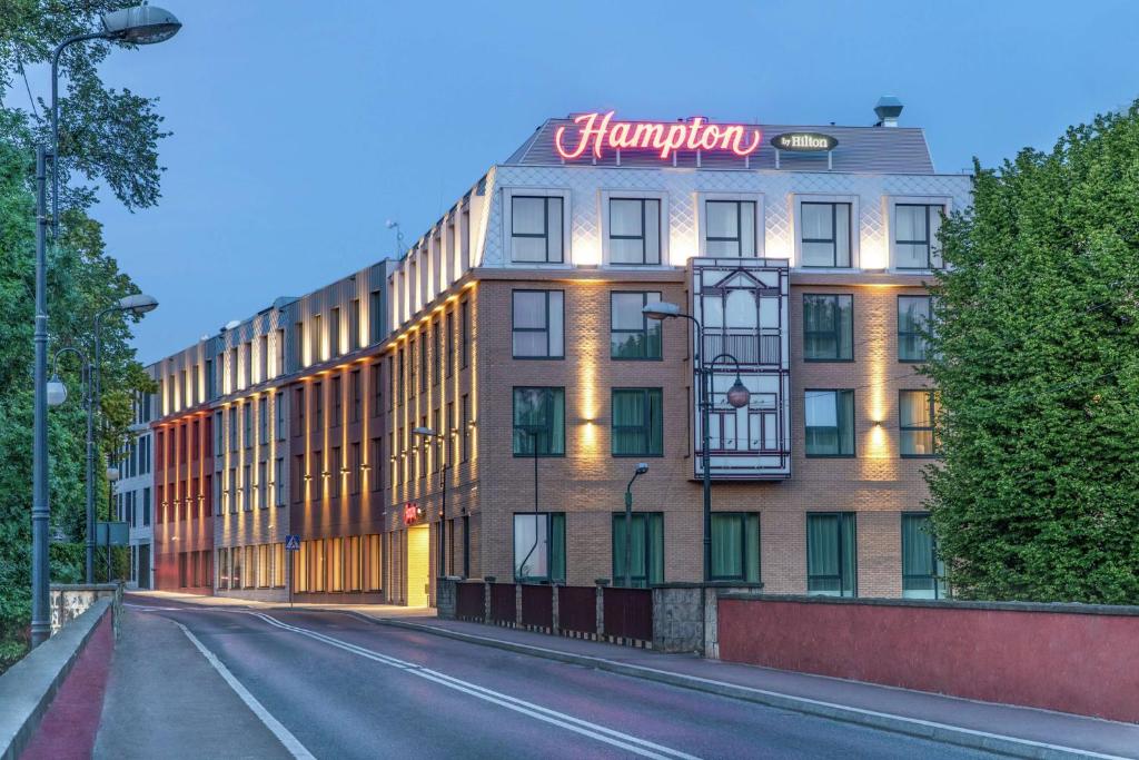 a building with a sign on the top of it at Hampton by Hilton Oswiecim in Oświęcim