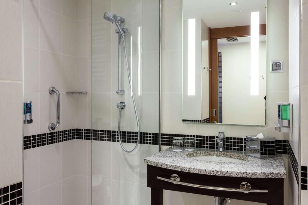 a bathroom with a sink and a shower at Hampton by Hilton Warsaw Airport in Warsaw