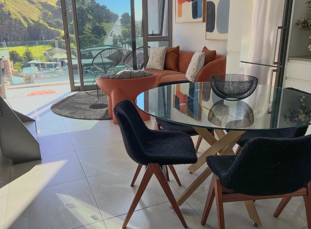 sala de estar con mesa de cristal y sillas en Ink Loft Apartment en Ciudad del Cabo