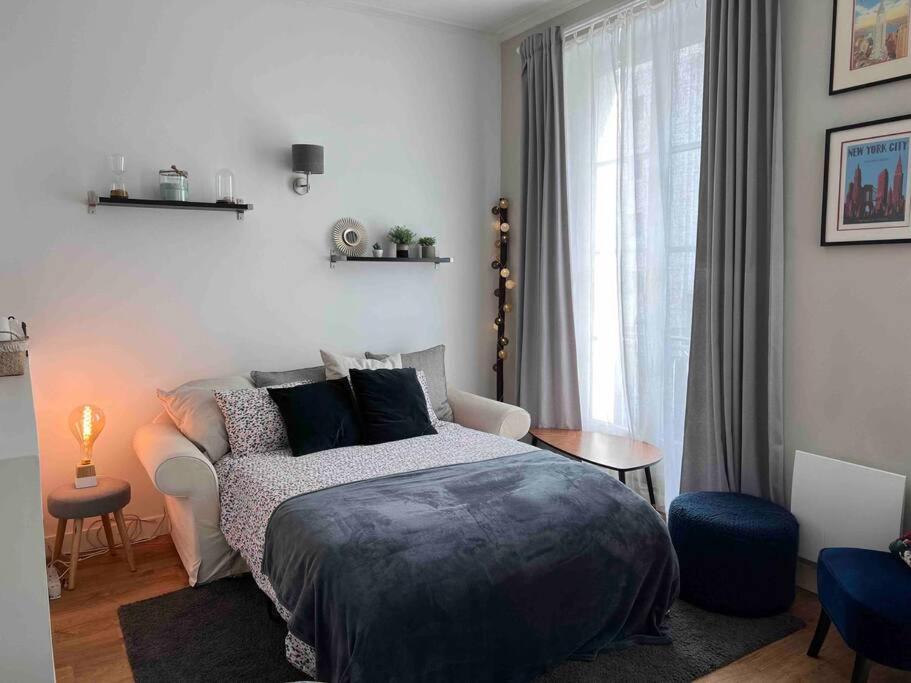 1 dormitorio con cama, sofá y ventana en Le Pawlina, en Nantes