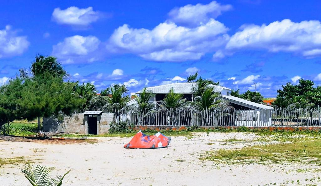 een huis op het strand met een oranje voorwerp in het zand bij Kite & Sol Beach House Taiba in Taíba