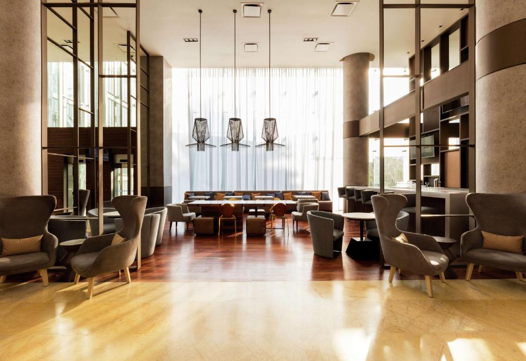 a lobby with a waiting room with chairs and tables at Doubletree By Hilton Mexico City Santa Fe in Mexico City