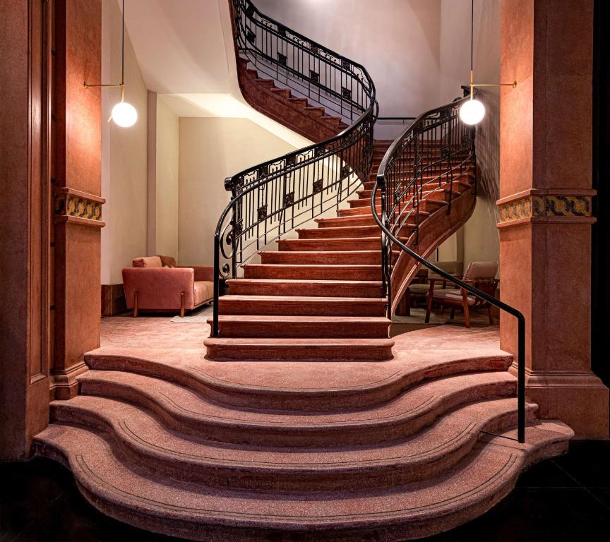 a spiral staircase in a building with a rug at Umbral, Curio Collection By Hilton in Mexico City